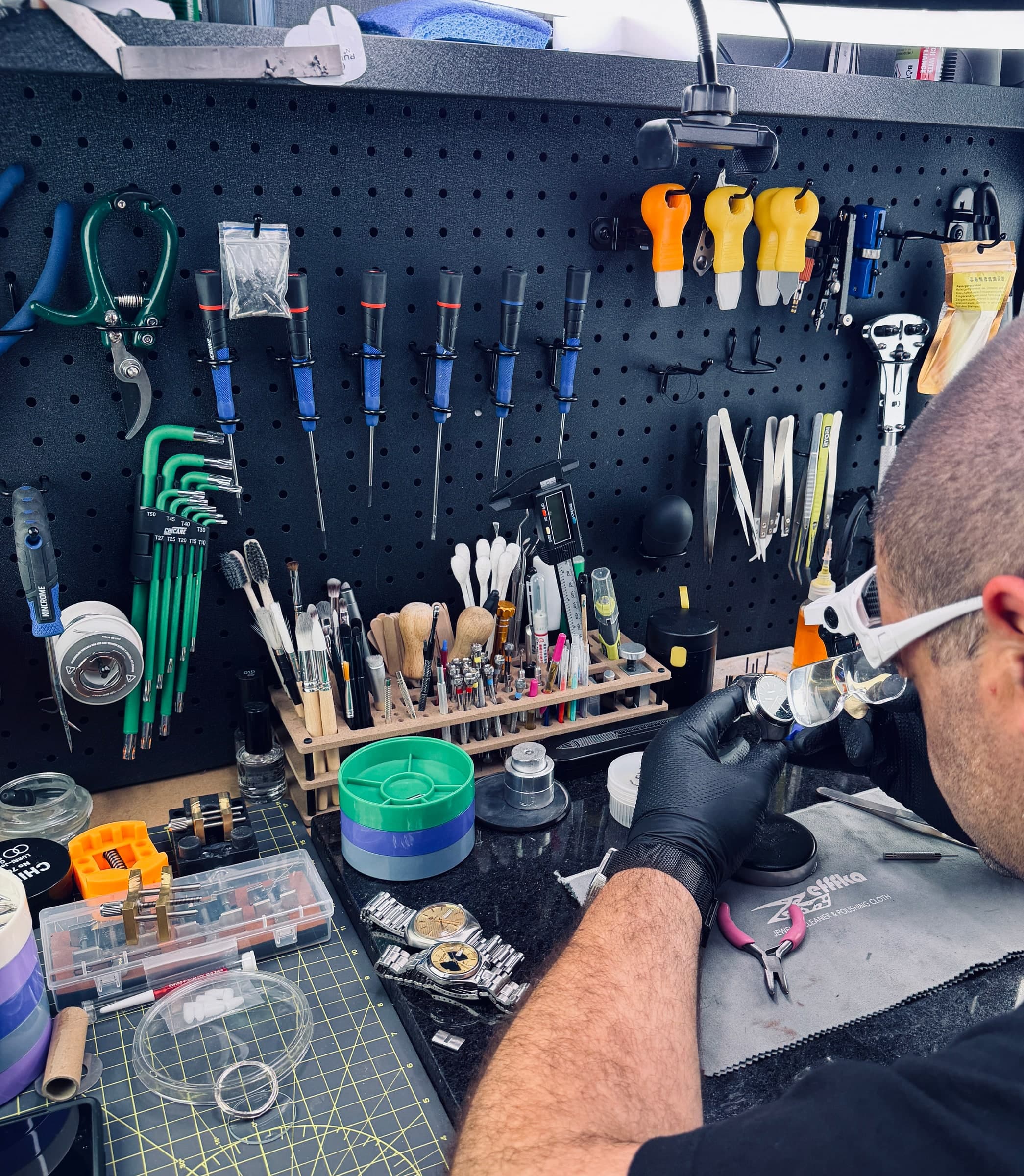 Alpha Gear Lab workshop — inspecting watches at the workbench